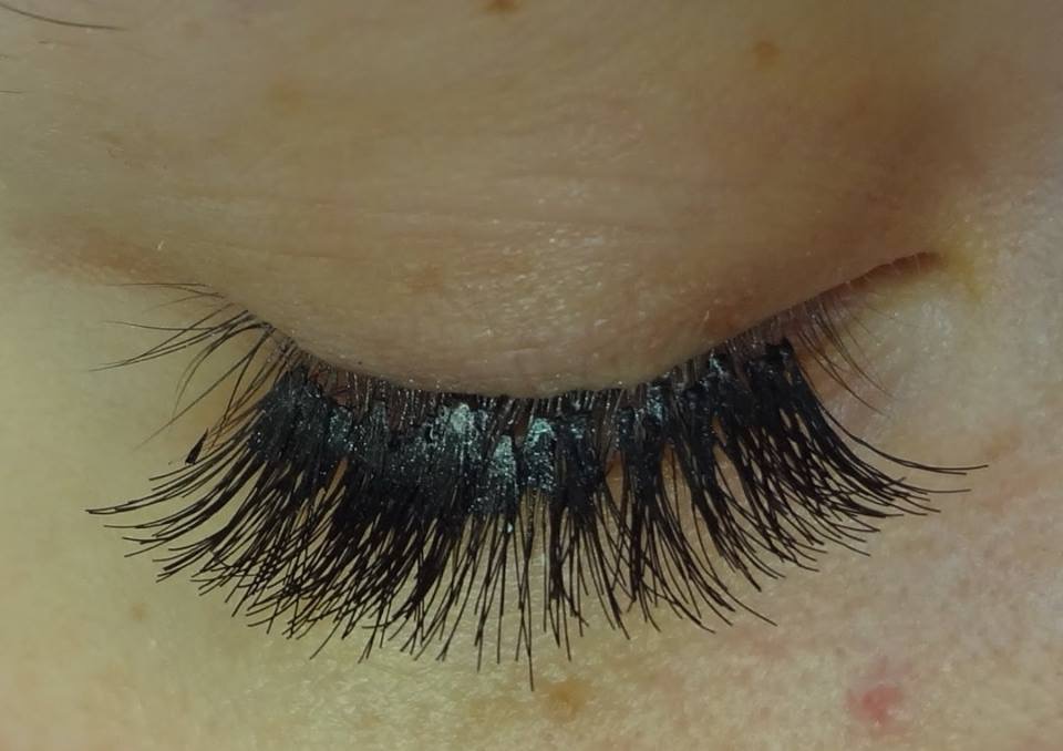 Geschlossenes AUge mit verklebten WImpern nach einer Wimpernverlängerung.Es sind große Klebepunkte zu sehen